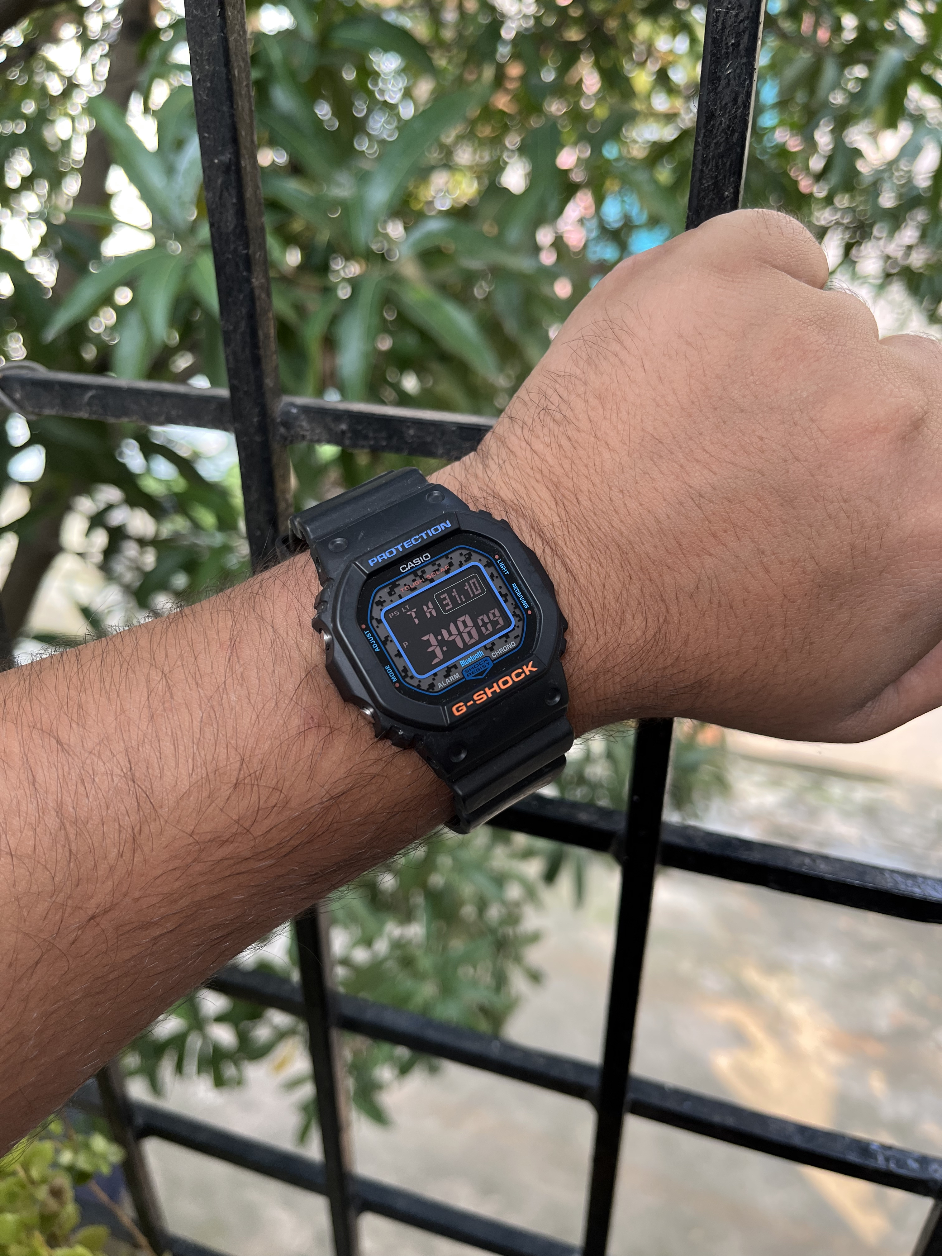My CASIO G-Shock GW-B5600 on the wrist, blue PROTECTION text and orange G-SHOCK logo on the bezel